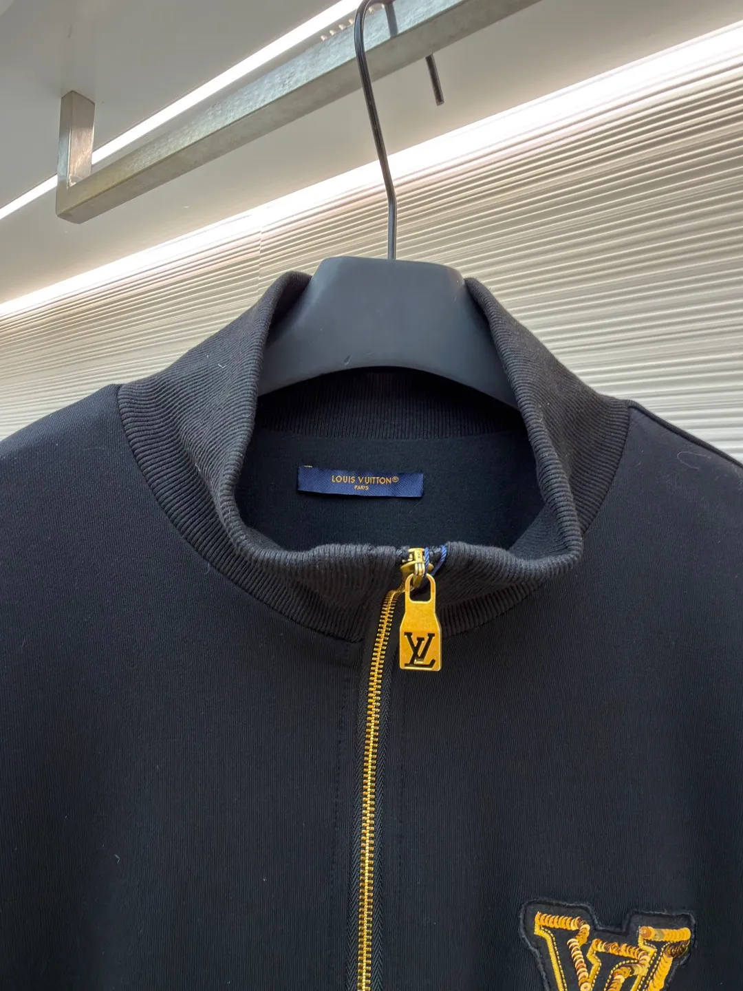 LOUIS VUITTON stand-up collar ribbed hem long-sleeved logo decorated jacket ●Original version: Purchased and developed at 25899 ●Item number: 1682404-B25 ●Fabric: cotton fabric ●Technology: knitted production ●Color: black ●Version: fitted version ●Weight: about 990 grams ●Size: S-M-L-XL ●Description: This Louis Vuitton stand-collar zipper jacket is made of high-thread-count cotton-elastic blended fabric, which has been treated with enzyme washing process. The fabric is soft to the touch and has good wrinkle resistance and elasticity. The body has a delicate matte texture. The LV logo on the chest uses a combination of gold thread embroidery and patchwork. The embroidery uses interlaced flat stitch and chain stitch techniques. The stitch density reaches 12 stitches per centimeter. The edges are overlocked and the pattern is three-dimensional and not easy to fall off. The jacket adopts a stand-up collar design, and the collar ribs are made of spandex blended material, which has been shaped to ensure that it will not loosen after long-term wear. The front is equipped with a custom brass zipper, and the zipper teeth are polished and gold-plated, making it smooth, wear-resistant and of high-quality texture. The side seam pockets are welted, and the seams are reinforced with double-needle sewing. The ribbed edges of the cuffs and hem are woven with high-elastic yarns of the same color. The shoulders are seamlessly spliced ​​with natural shoulder shapes. The overall craftsmanship combines the brand's classic elements with practical design, fully demonstrating the production level of high-end clothing. The overall wiring is straight and delicate, the fabric is comfortable and soft, and the color is consistent without color difference. It can be matched with the same style to create a fashionable look and control various occasions. Customized accessories, complete with three standards, same style for men and women!